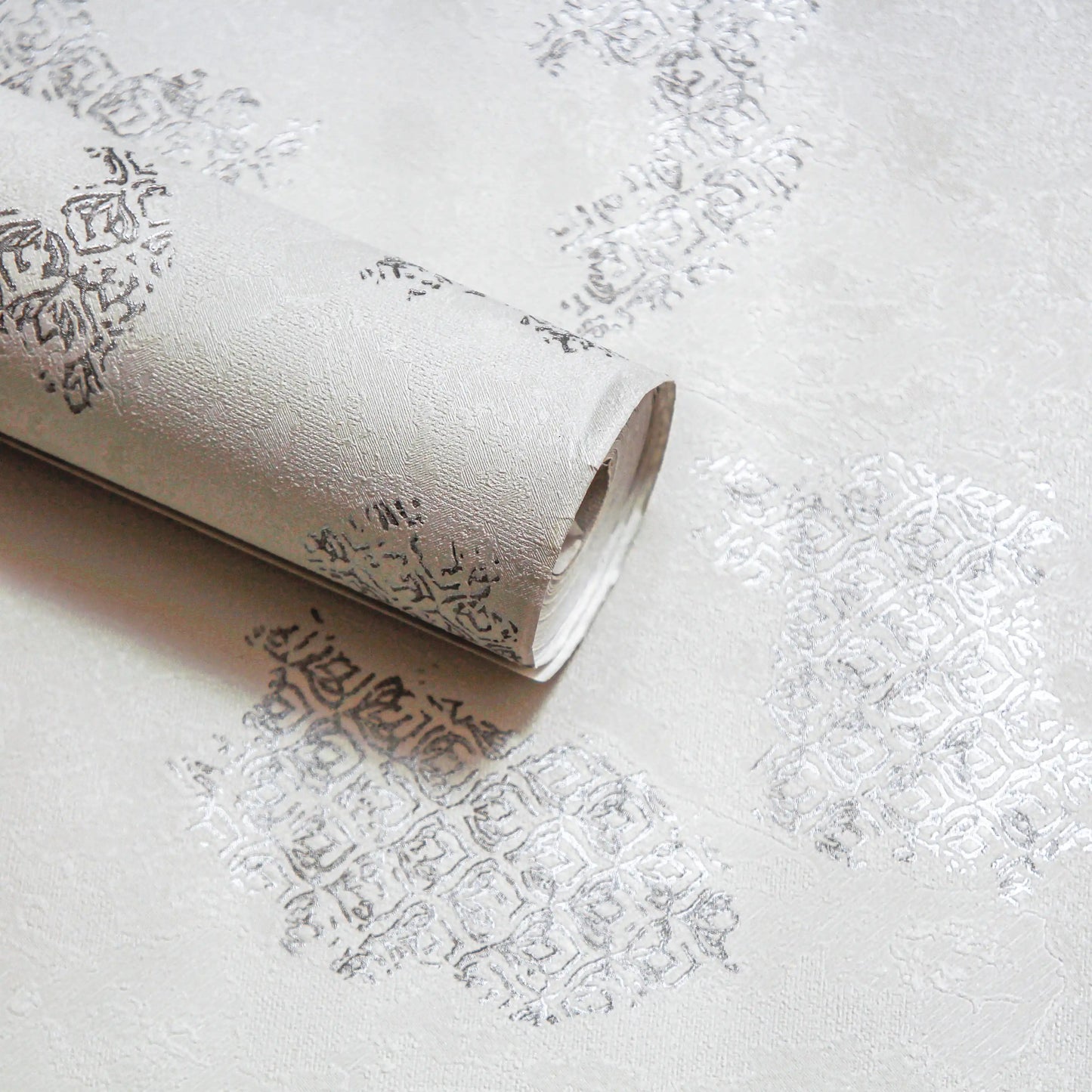 Roll of textured wallpaper on a light gray background