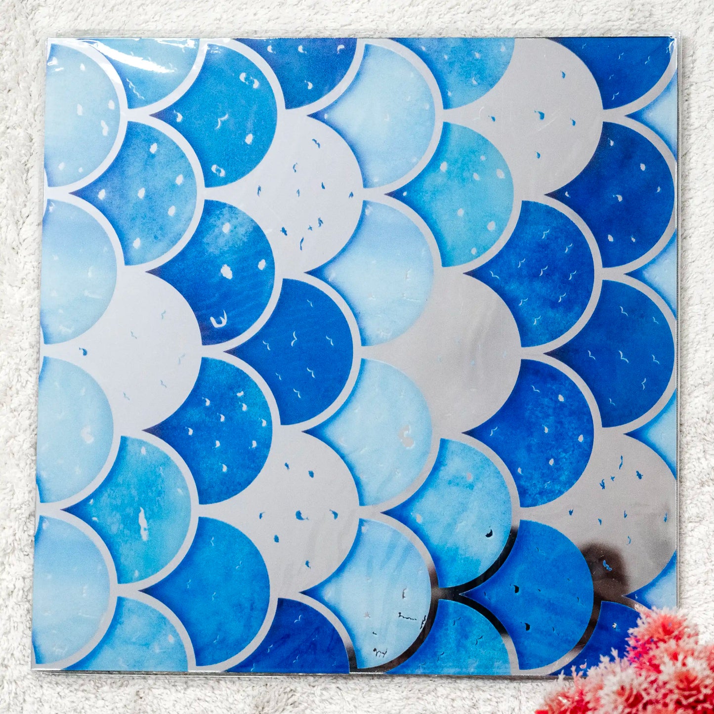Tile with blue and white circular pattern on a textured surface