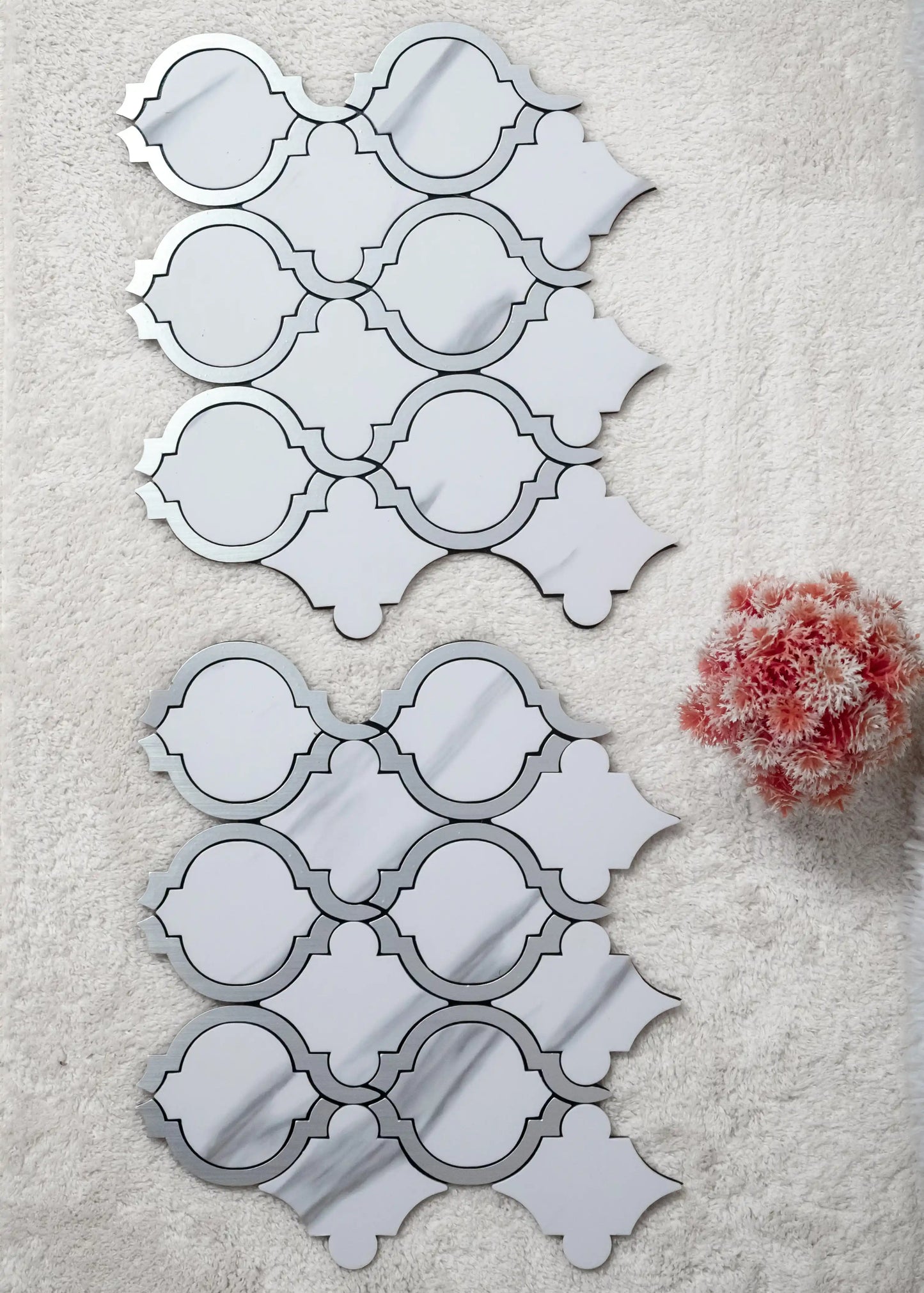 Decorative mirror panels with geometric patterns on a textured surface.