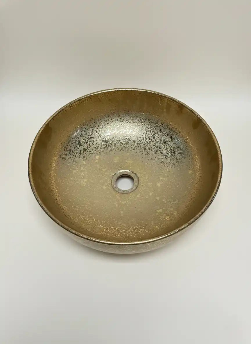 Round ceramic sink with speckled glaze on a white background