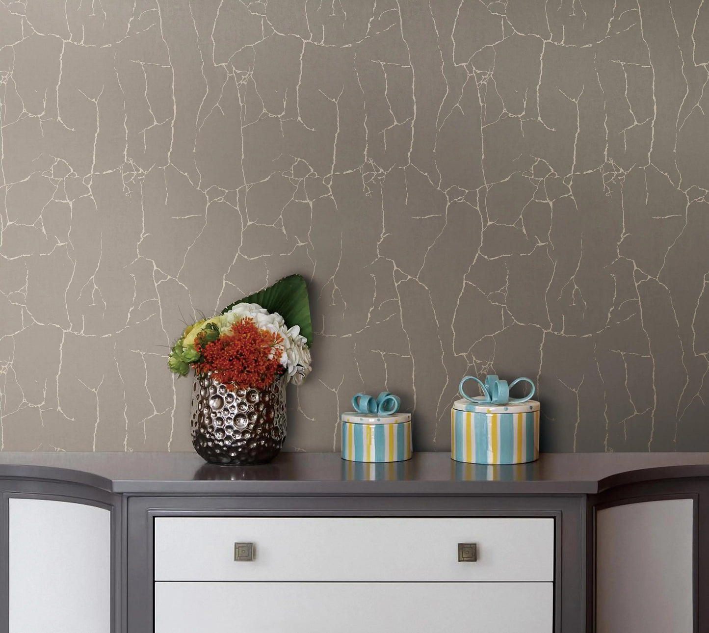 Decorative items on a dresser against a textured gray wall