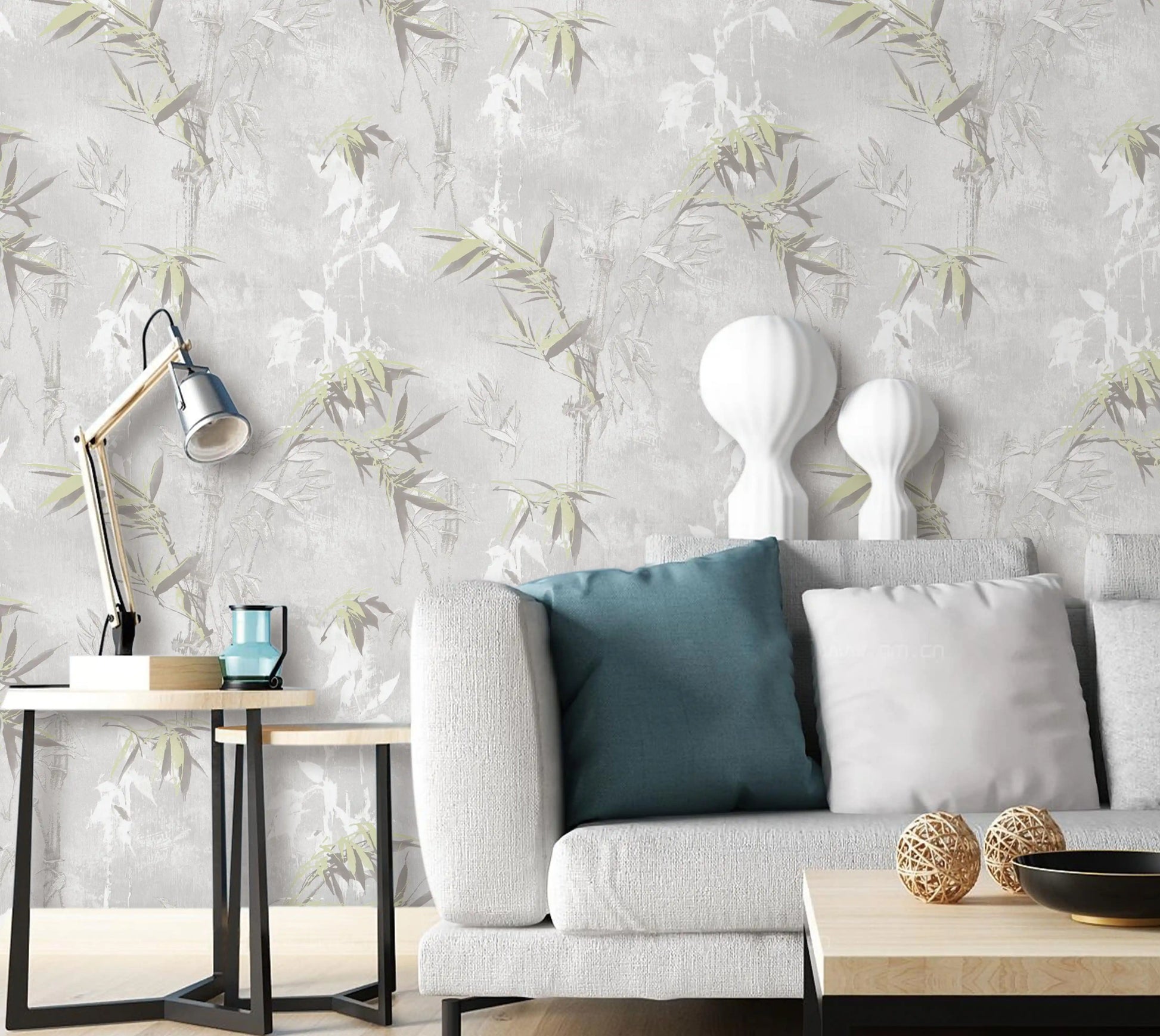 Living room with a gray sofa, decorative pillows, and a lamp against a floral wallpaper.