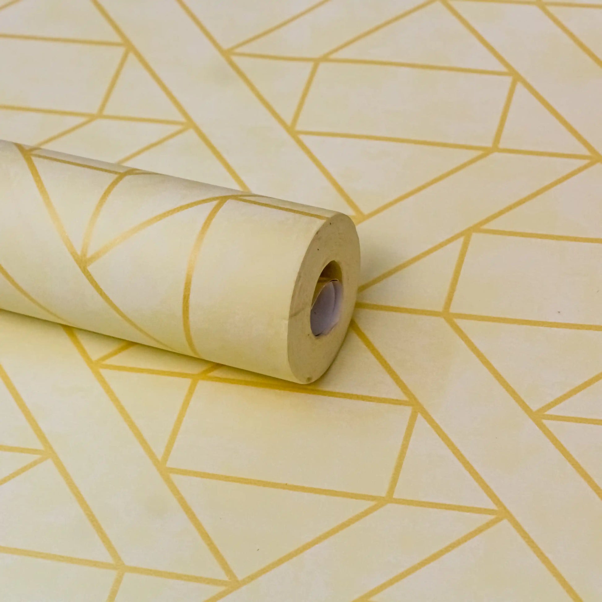 Roll of paper with geometric gold pattern on a matching background