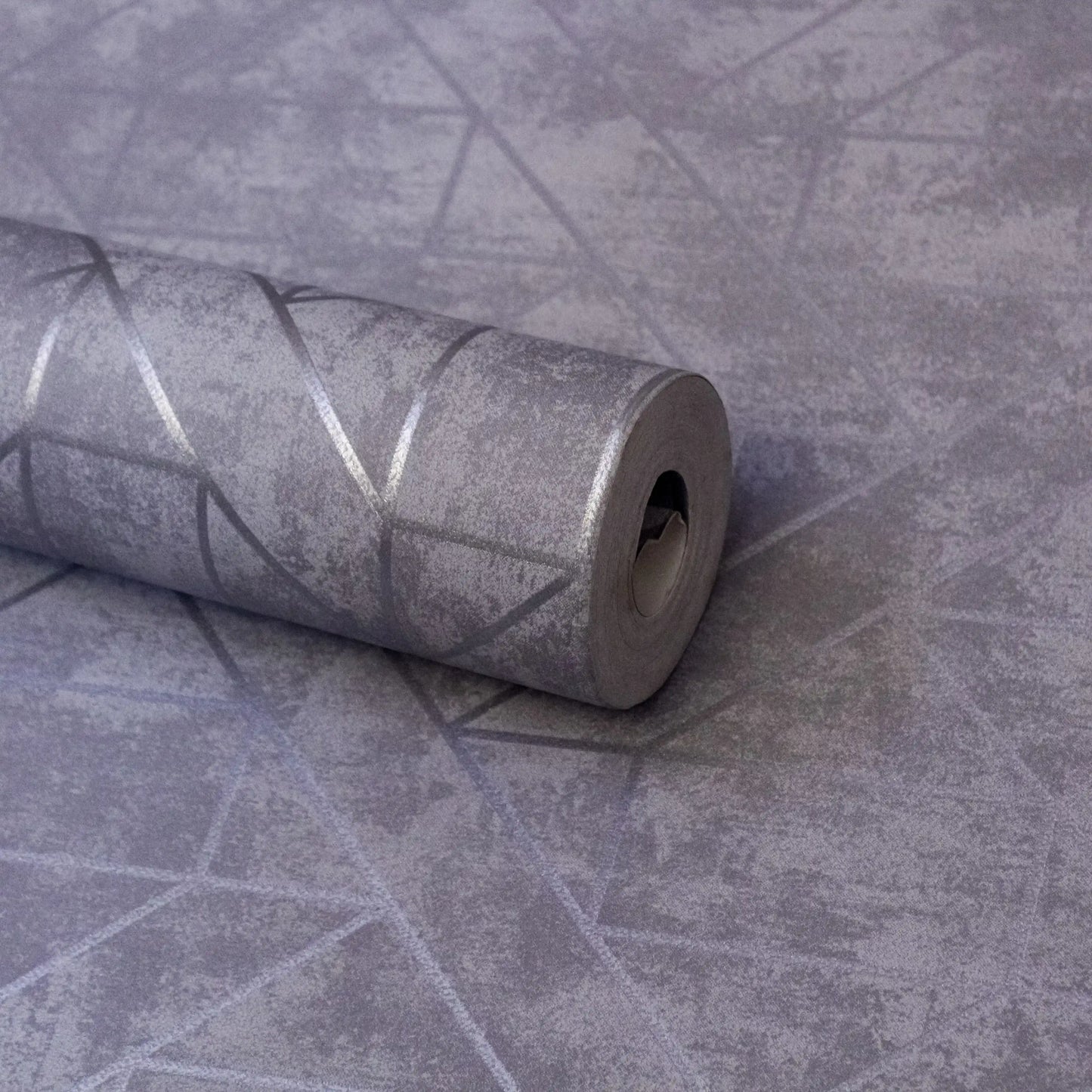 Roll of gray textured wallpaper on a matching background