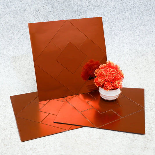 Set of orange mirror tiles with a small potted plant on a textured surface