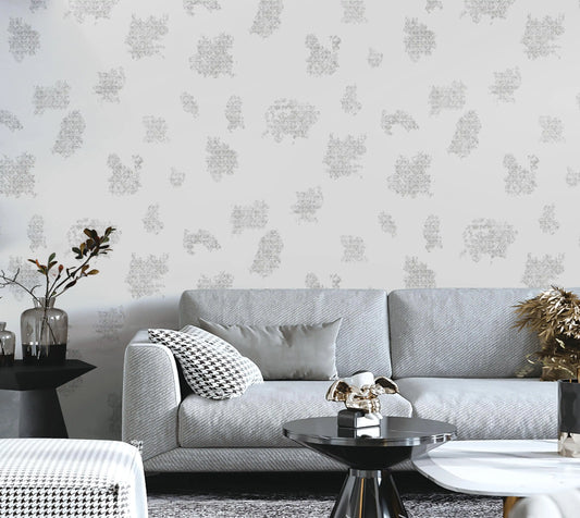 Living room with a gray sofa, decorative pillows, and a patterned wall.