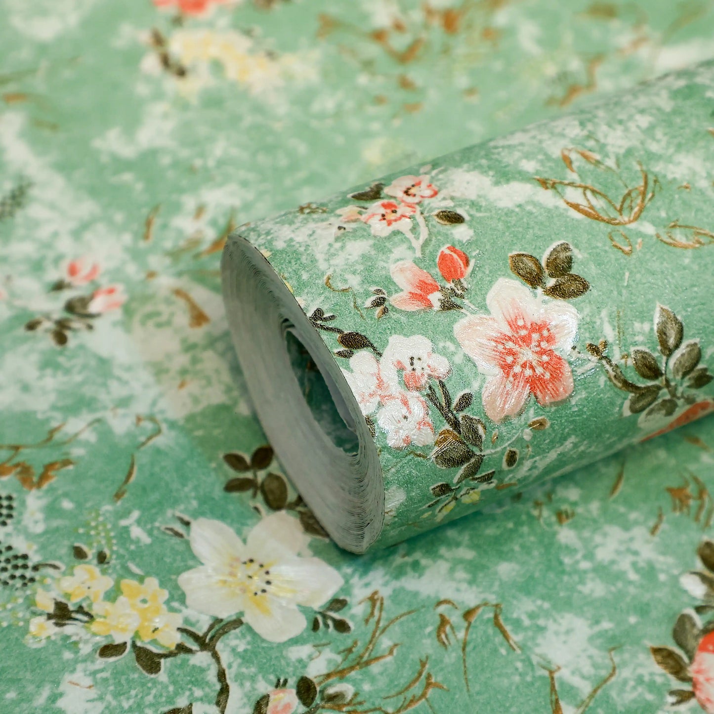 Roll of floral-patterned paper with pink and white flowers on a green background