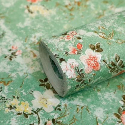 Roll of floral-patterned paper with pink and white flowers on a green background