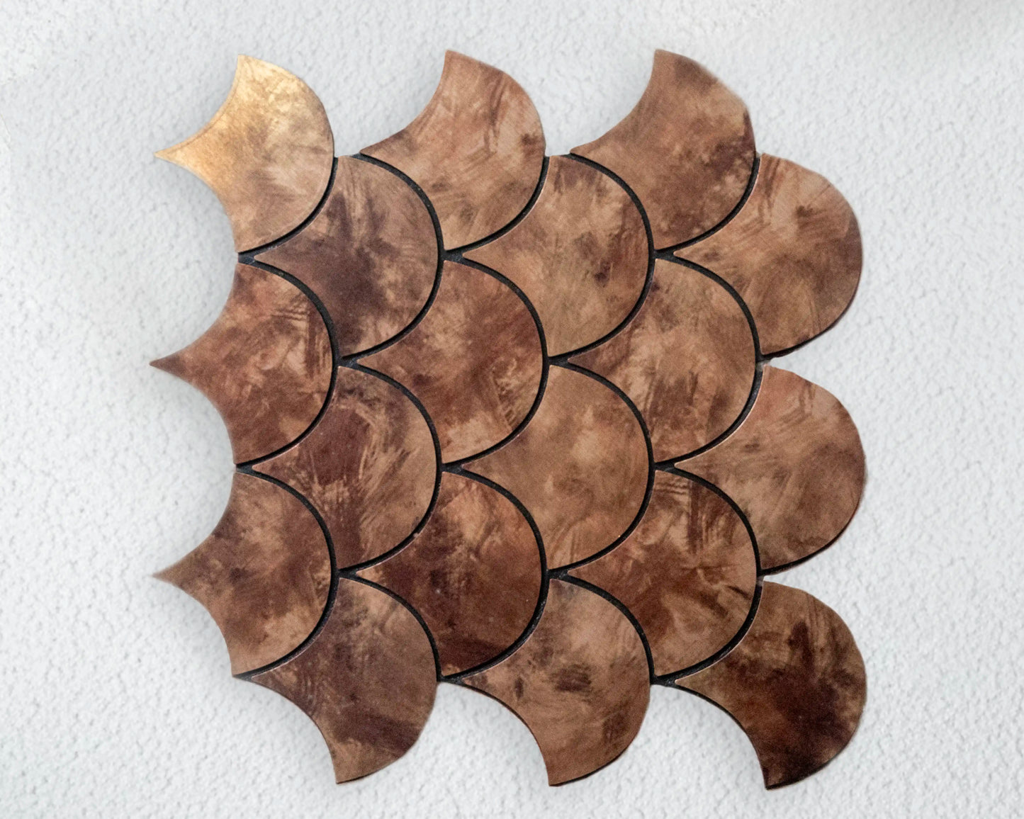 Decorative brown tile with scalloped edges on a white background