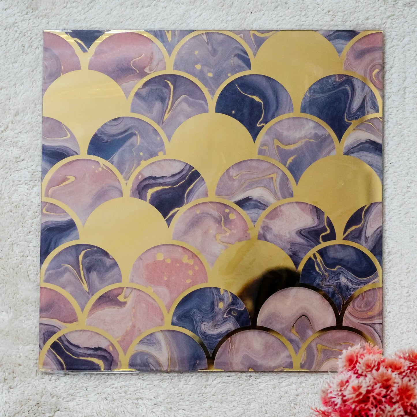 Decorative wall art with gold and purple abstract pattern on a textured wall.