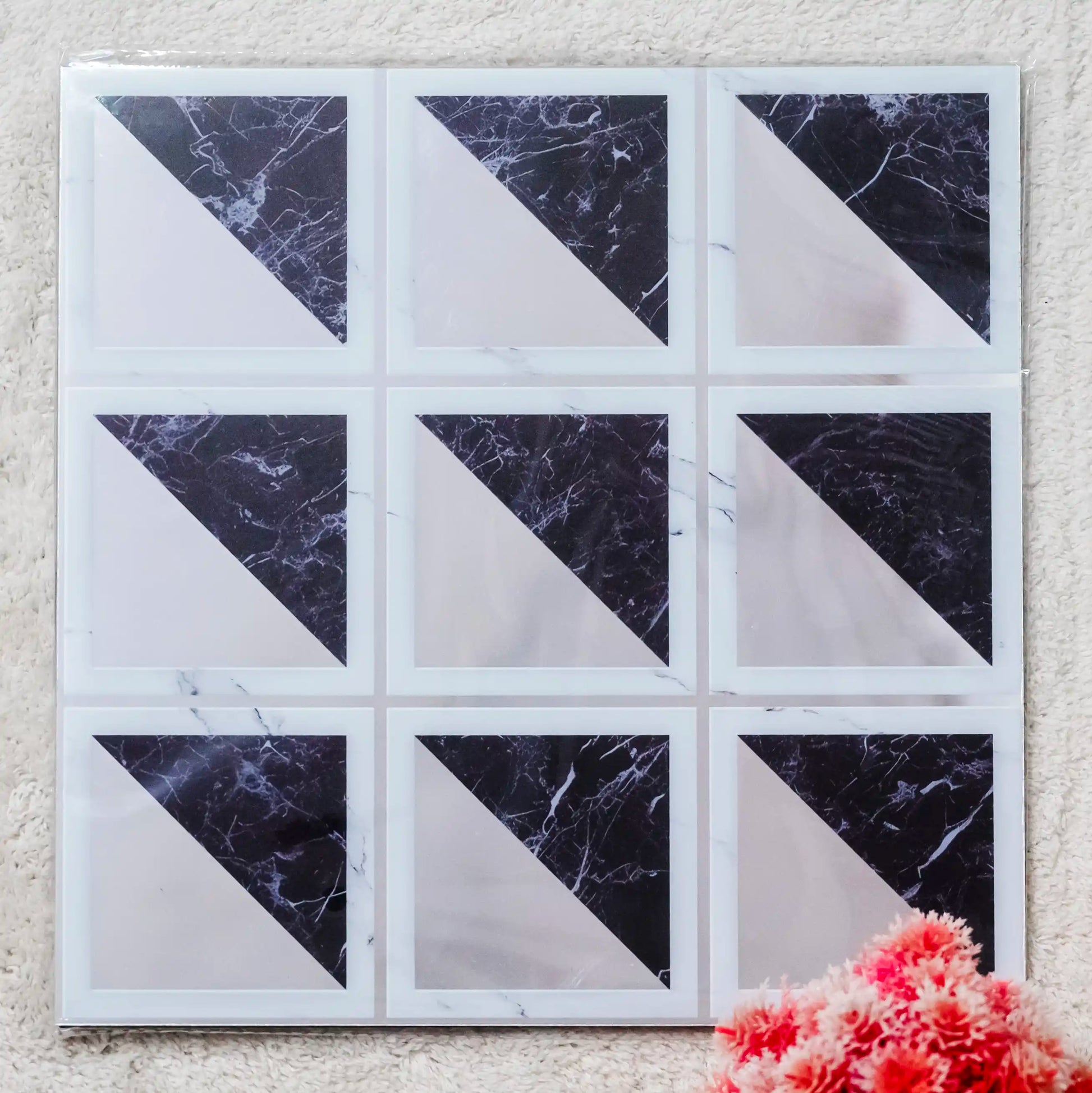 Marble-patterned tiles arranged in a grid on a textured wall.