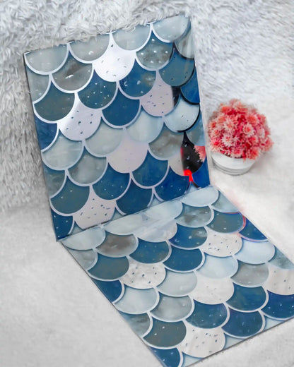 Two decorative mats with fish scale pattern on a white surface
