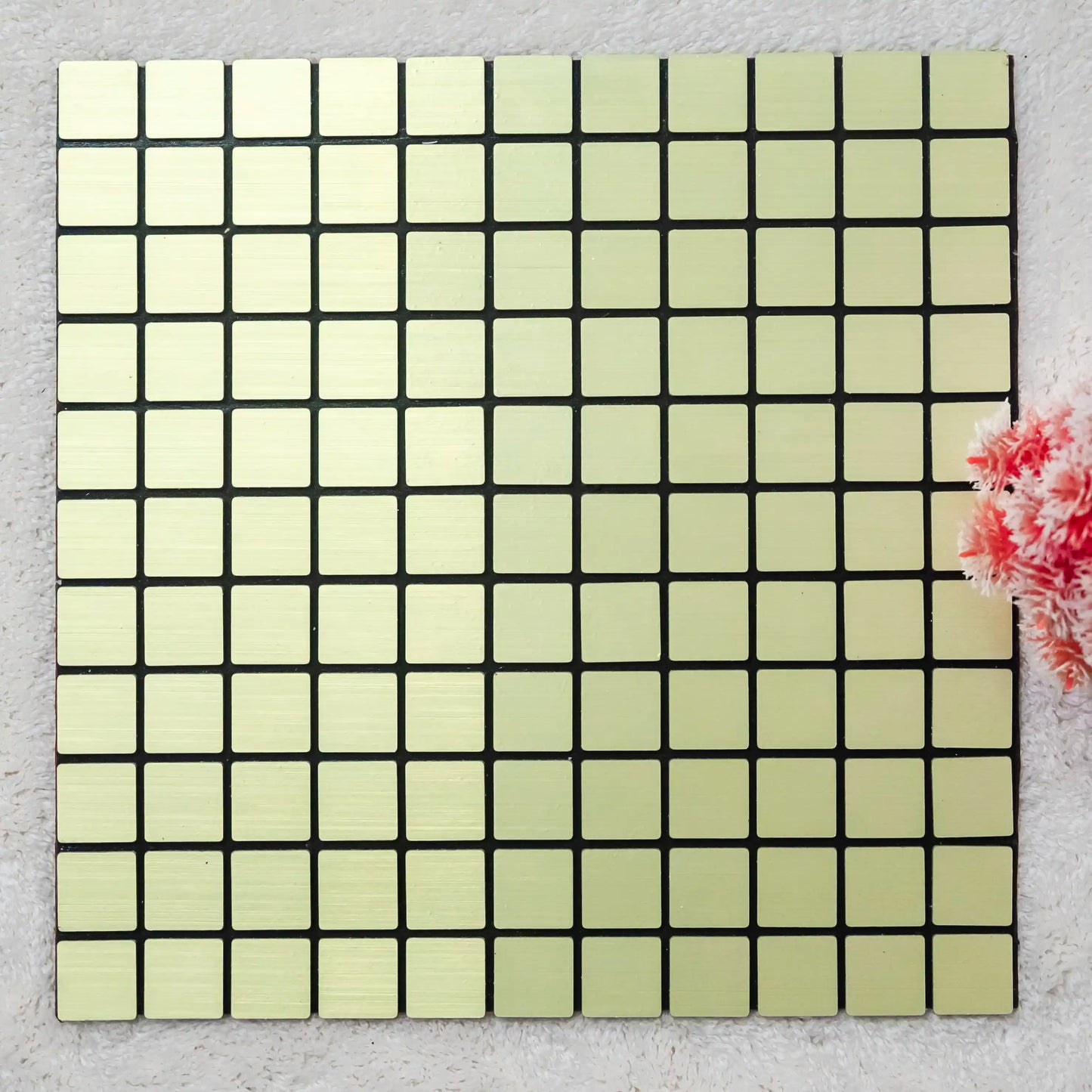 Square tile with a grid pattern on a textured surface