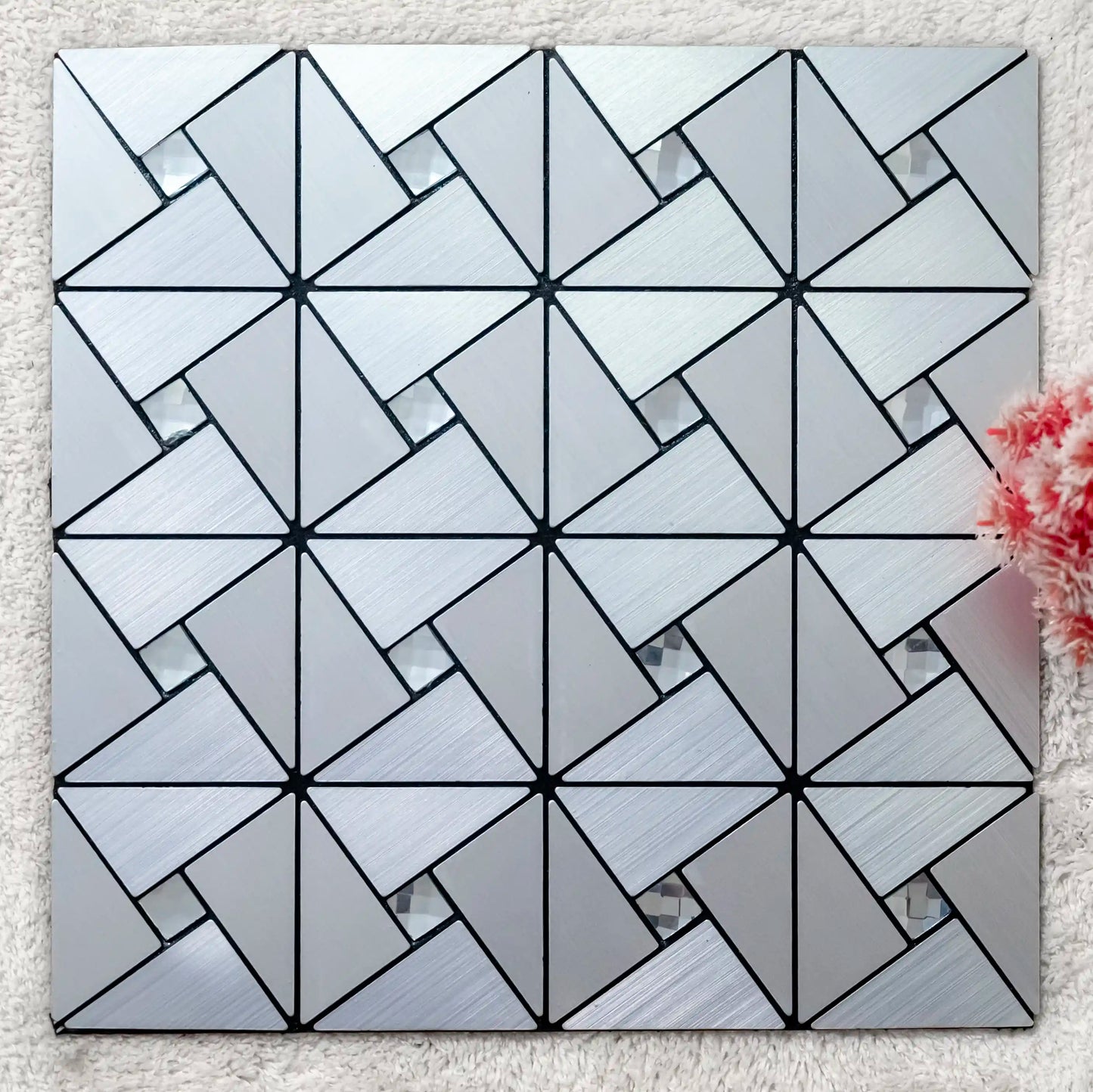 Geometric patterned tile on a textured surface with a floral arrangement.