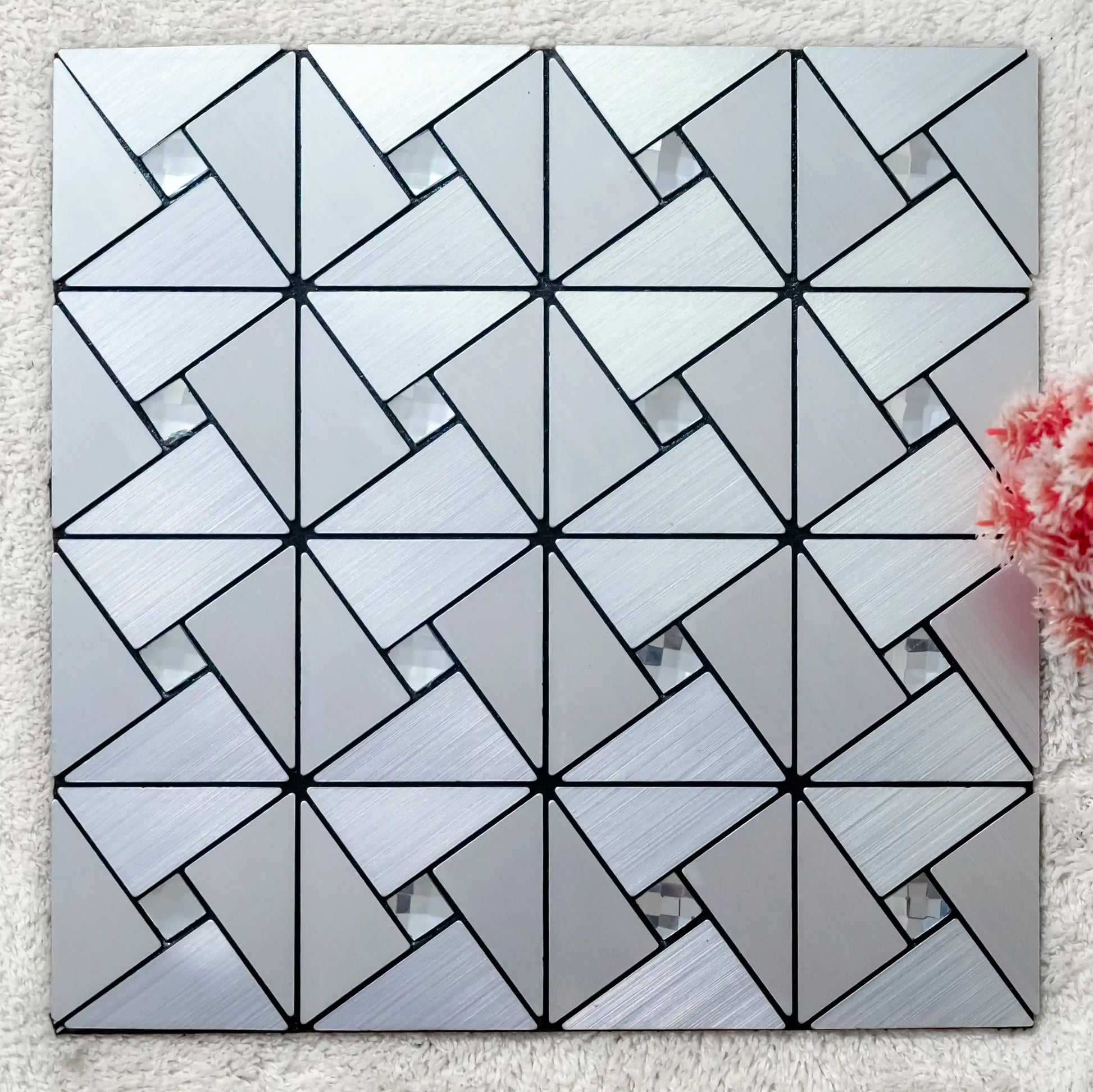 Geometric patterned tile on a textured surface with a floral arrangement.