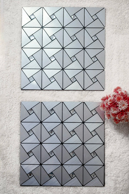 Two geometric-patterned mirrors on a light gray wall with a small plant.