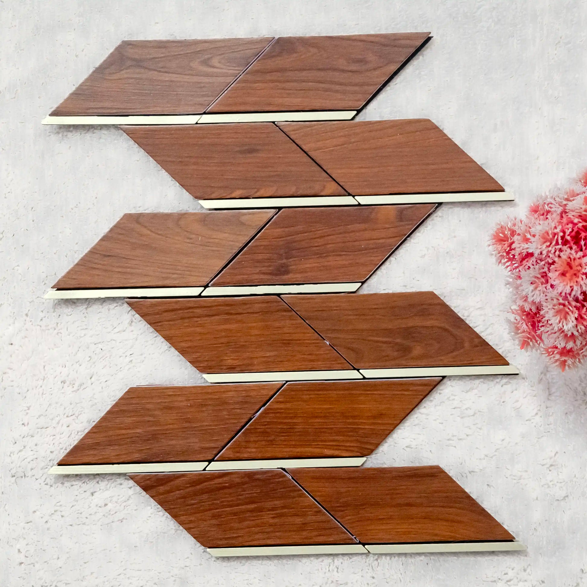 Wooden tiles arranged in a geometric pattern on a textured surface with flowers.