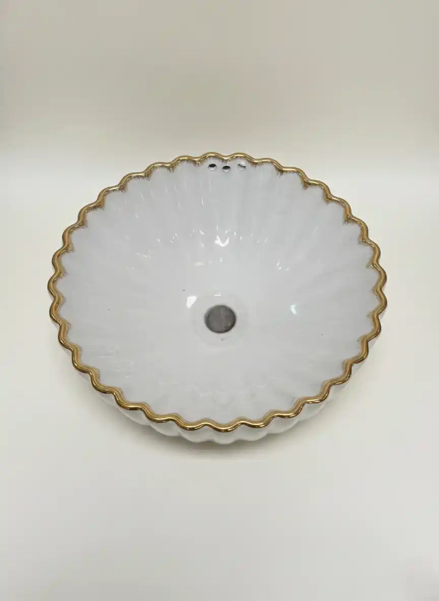 White ceramic bowl with gold rim on a white background
