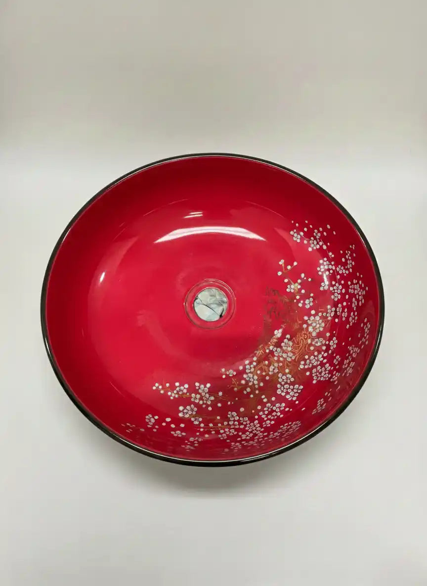 Red ceramic bowl with black rim on a white background