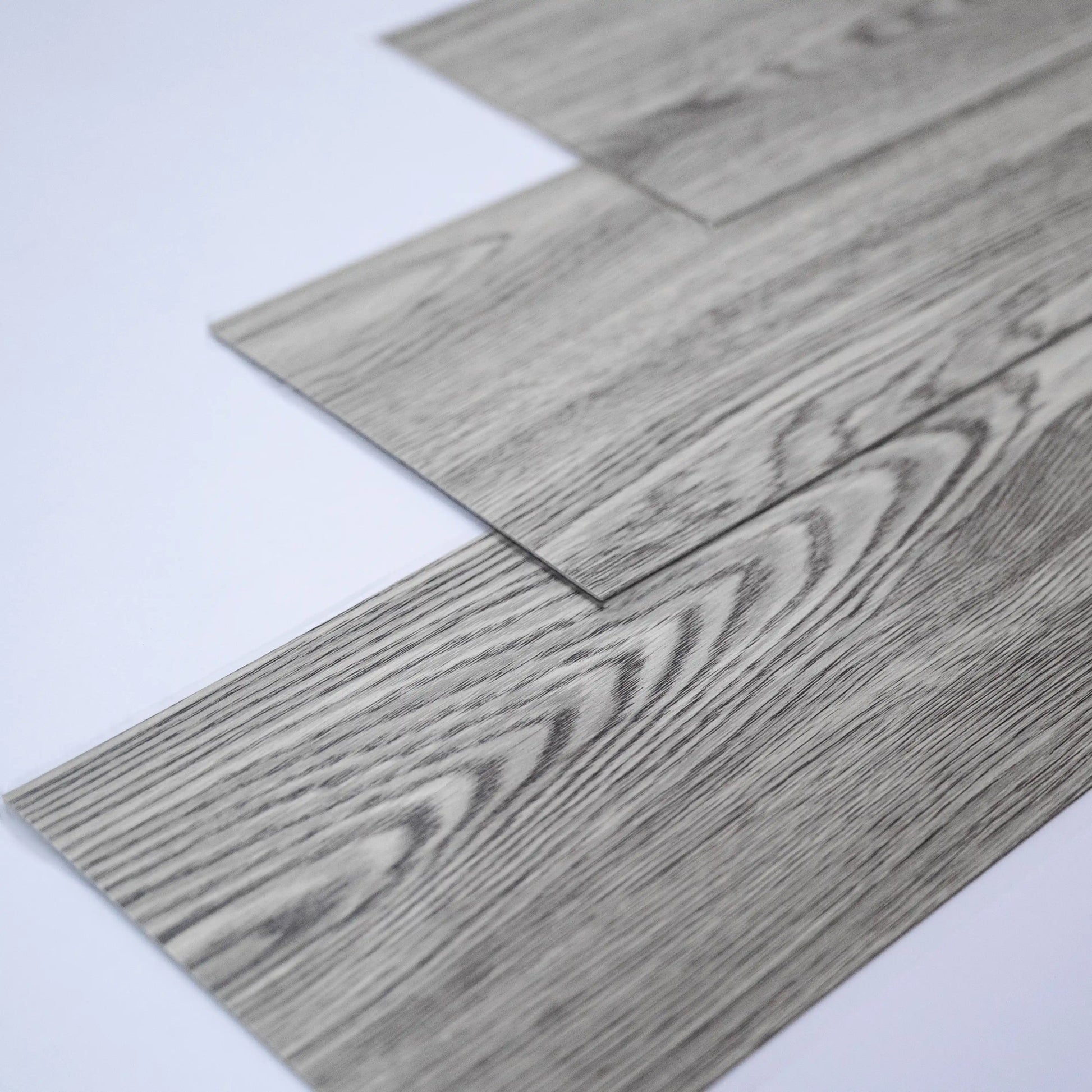 Close-up of gray wood-patterned flooring tiles on a white background