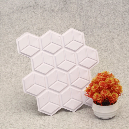 Hexagonal silicone mold on a gray surface with a small potted plant.