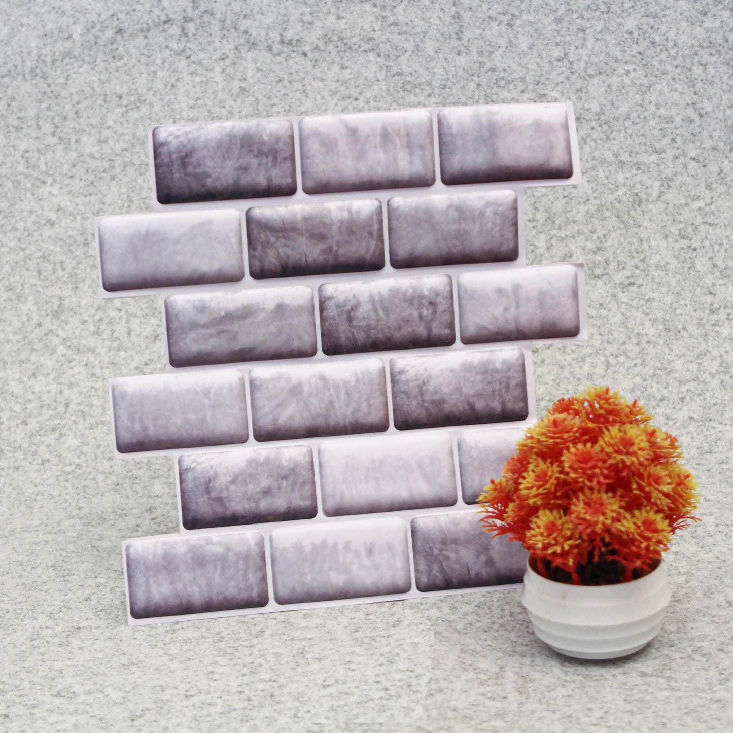 Decorative wall stickers resembling bricks on a textured wall with a potted plant.