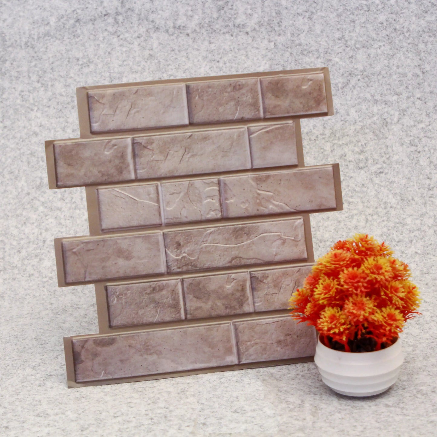 Decorative stone tiles on a textured surface with a potted plant.
