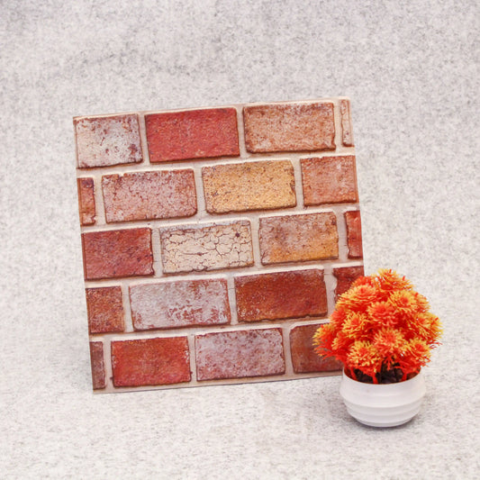 Brick-patterned decorative tile on a textured surface with a potted plant.