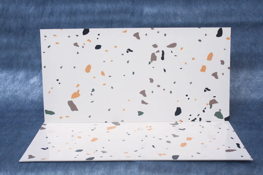 Terrazzo-patterned paper on a blue textured background