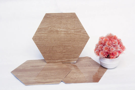 Hexagonal wooden tiles on a white surface with a small potted plant.