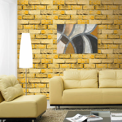 Modern living room with yellow brick wall, beige sofa, and abstract painting.