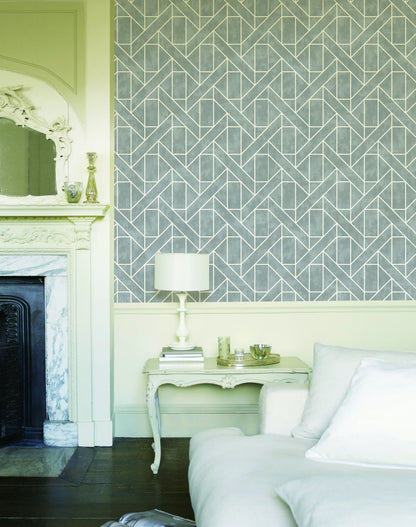 Neatly decorated room with geometric wallpaper, a fireplace, and a side table.