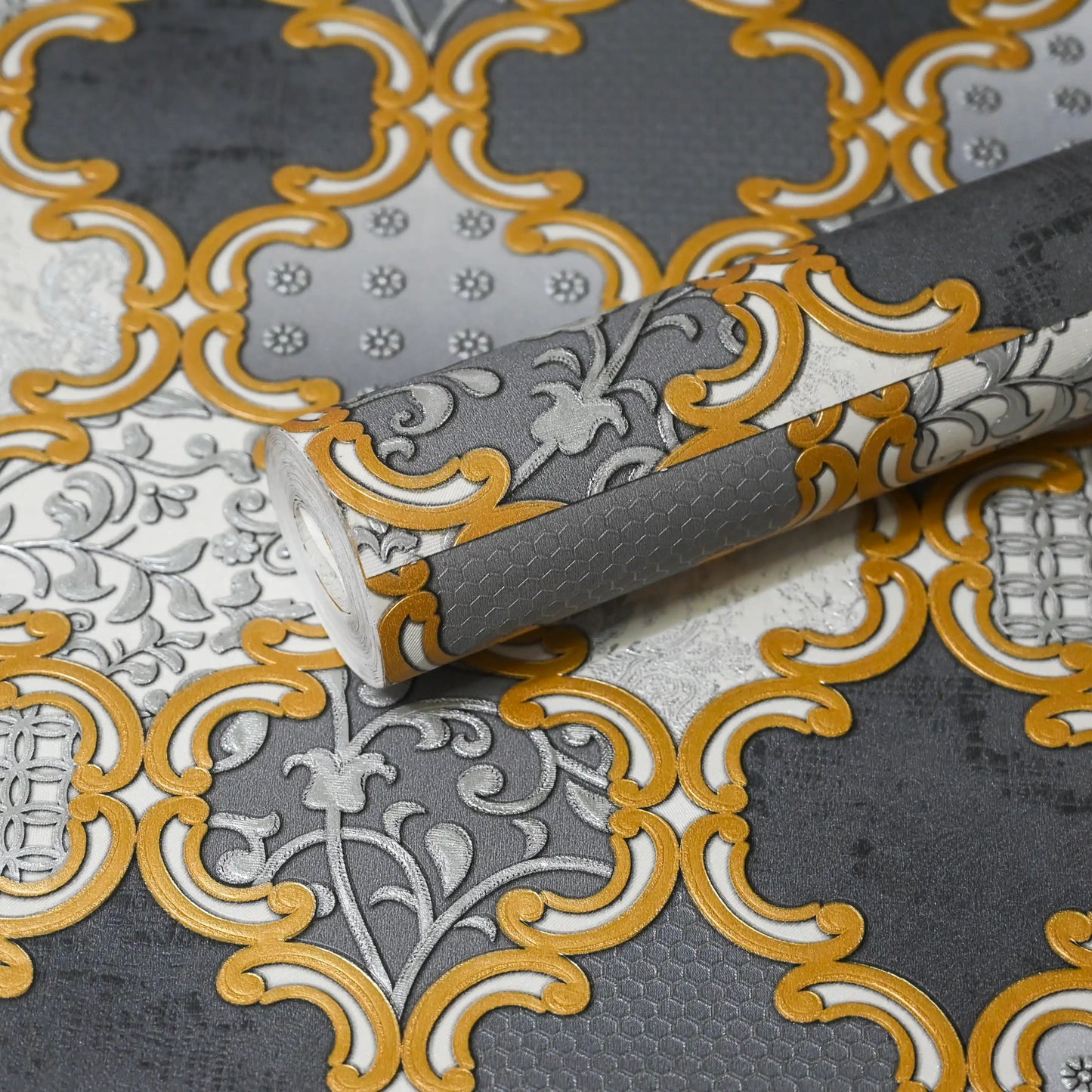 Decorative wallpaper with gold and gray pattern on a textured surface