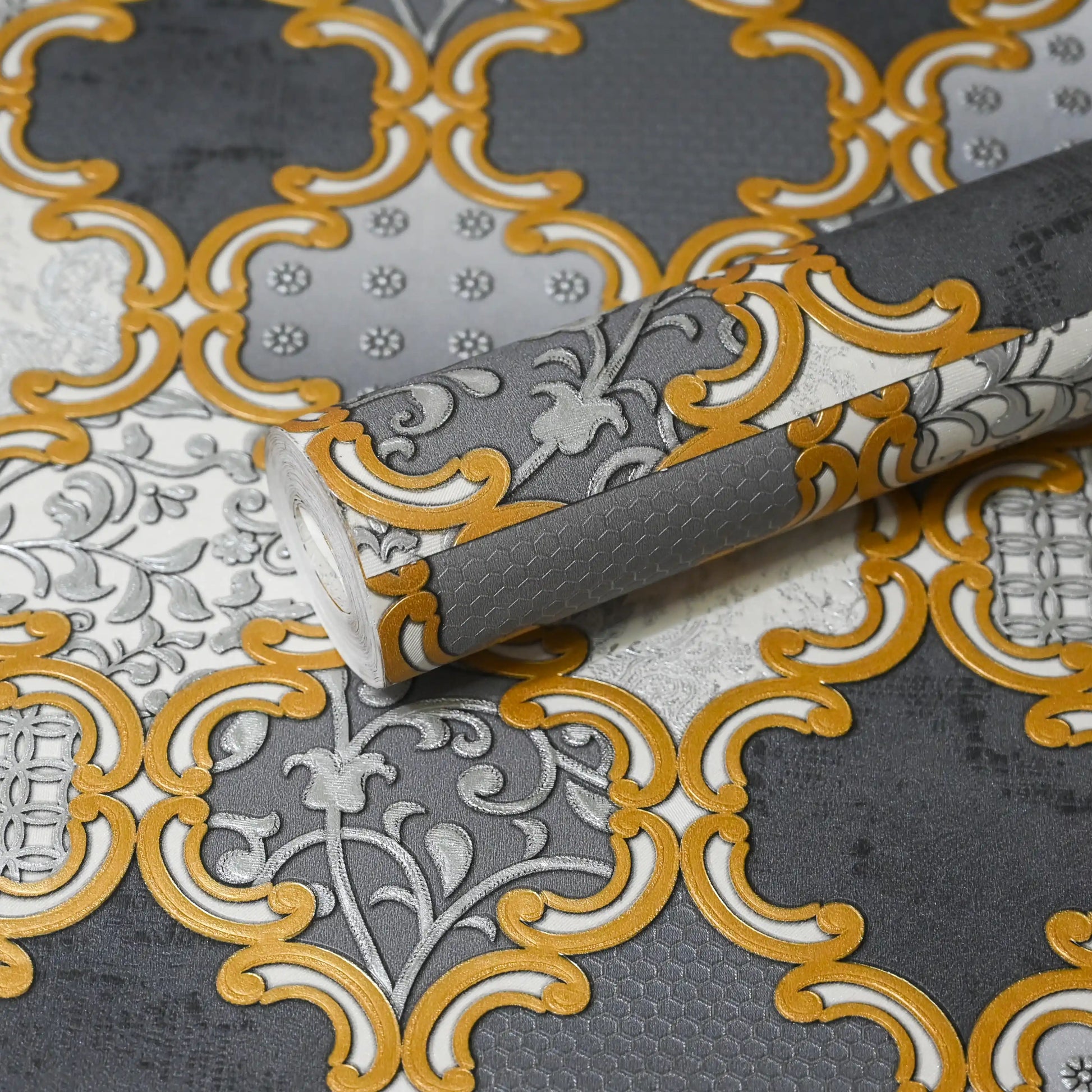 Decorative wallpaper with gold and gray pattern on a textured surface