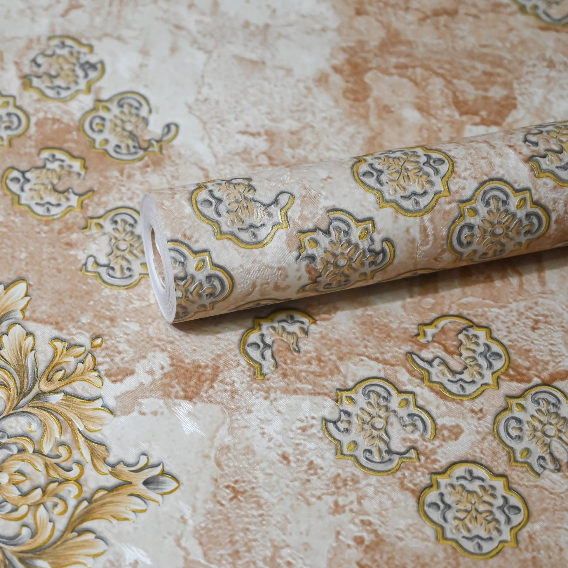 Roll of decorative wallpaper with intricate patterns on a textured surface