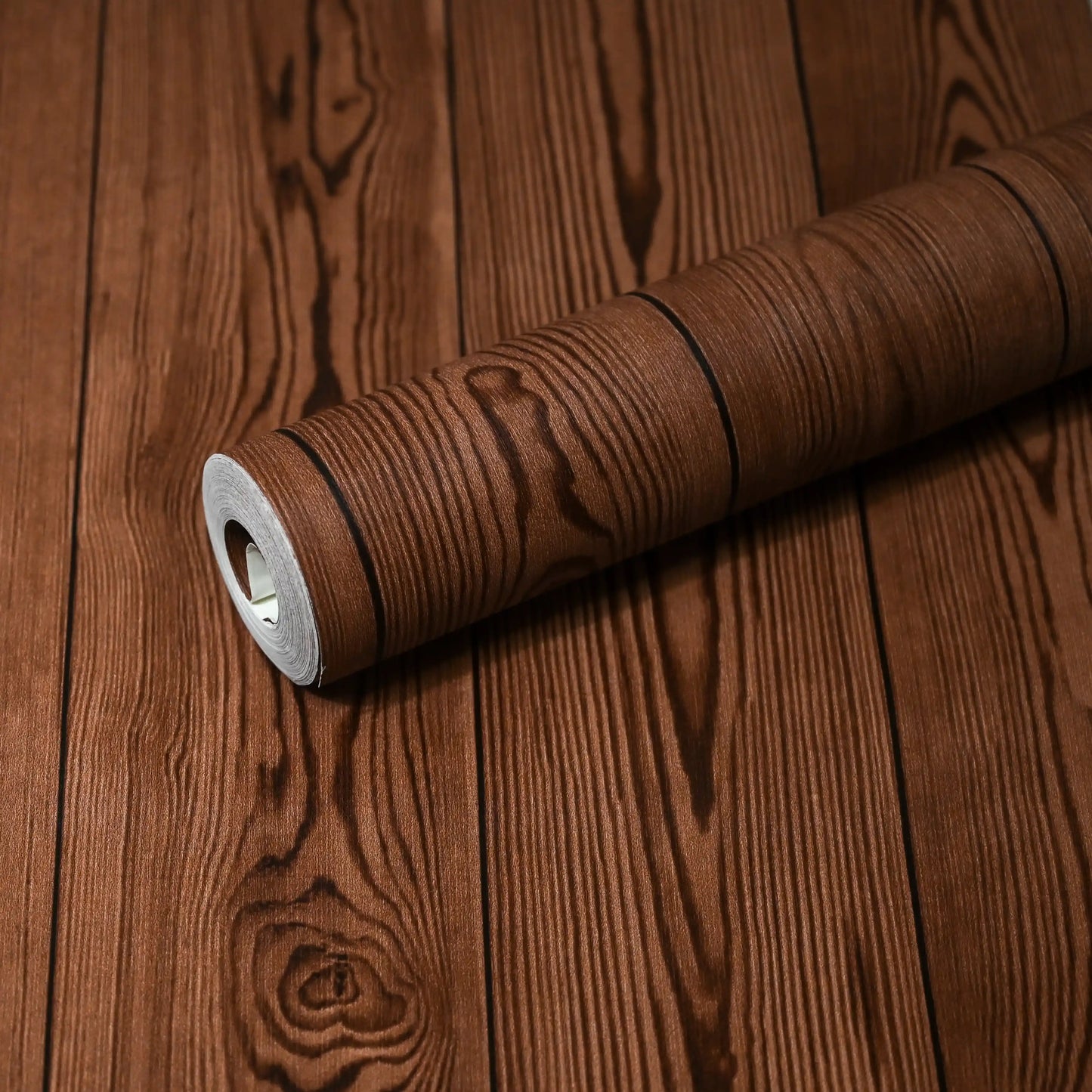 Roll of brown textured wallpaper on a wooden surface