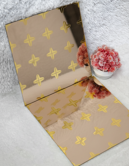 Beige paper with gold star pattern on a white surface with decorative items.
