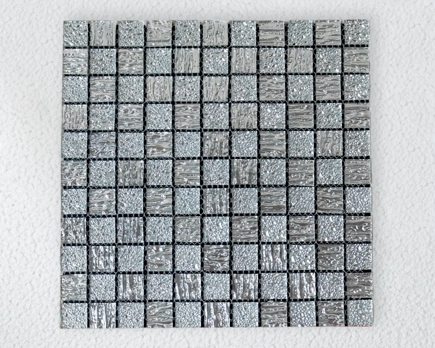 Square mosaic tile with a grid pattern on a light gray background