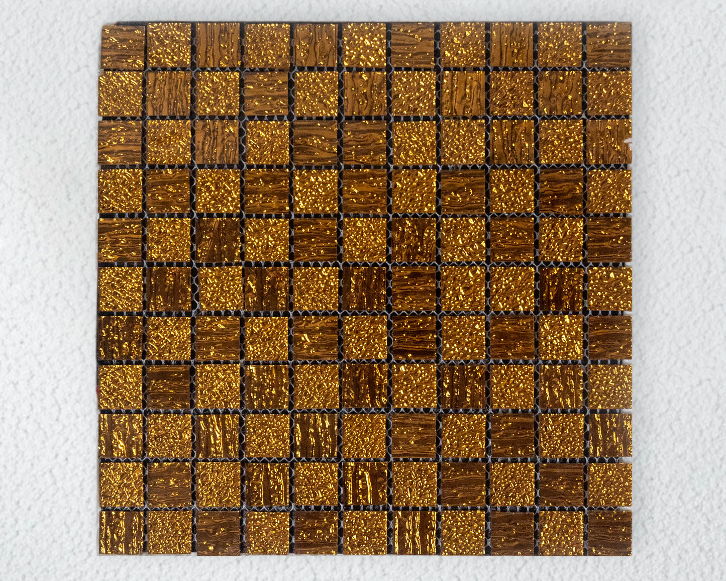 Square tile with gold and bronze mosaic pattern on a white background