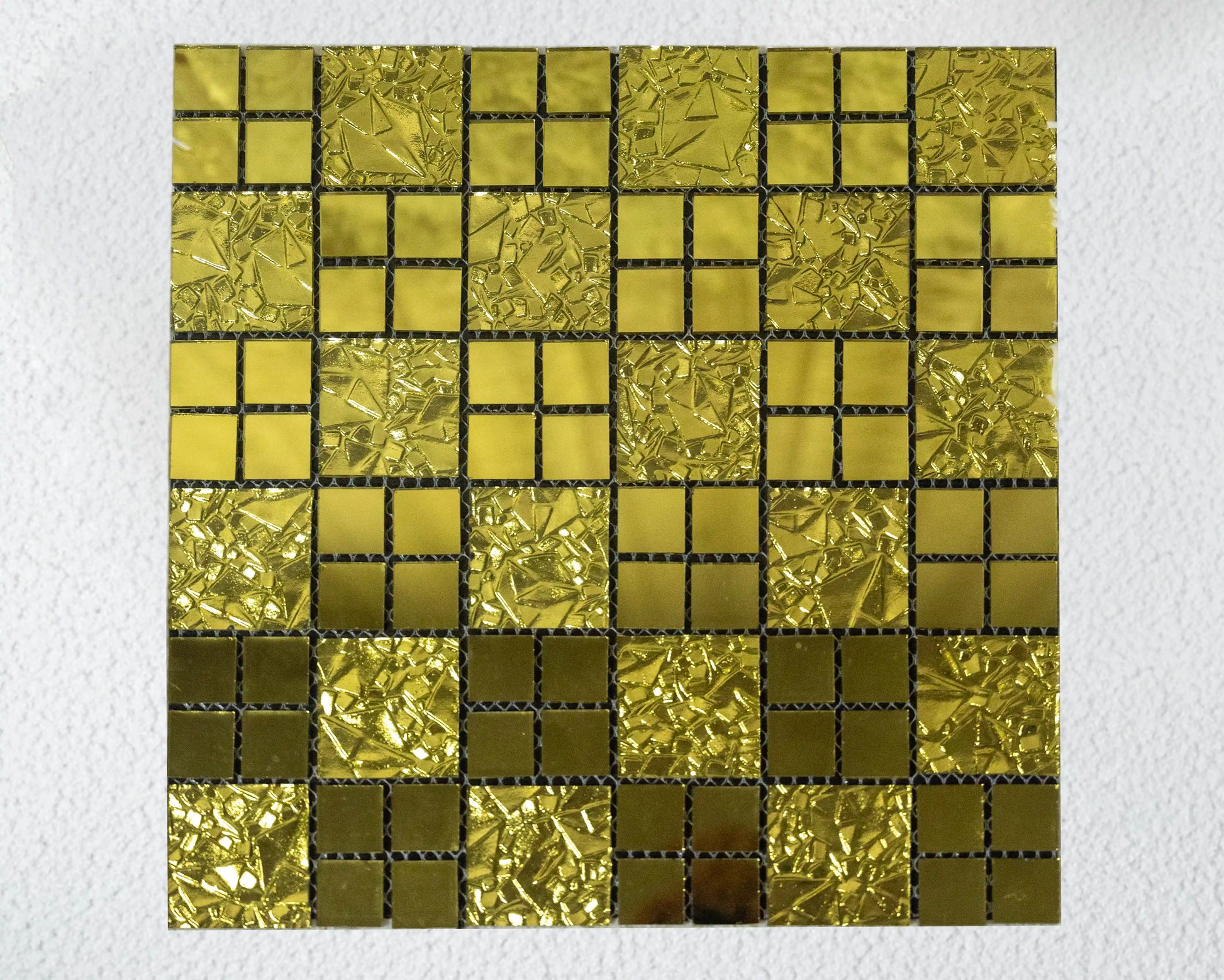 Gold mosaic tile pattern on a white background