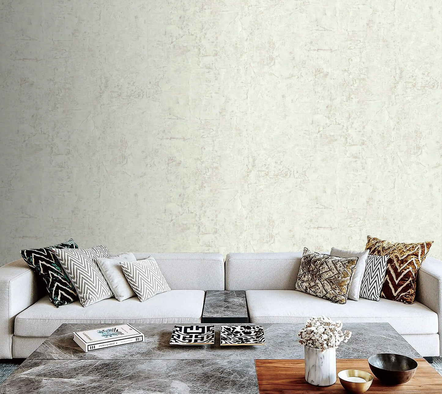 Modern living room with a gray sofa and decorative items against a textured wall.