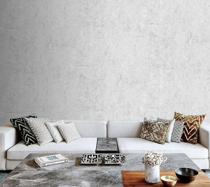 Modern living room with a white sofa and decorative pillows against a gray textured wall.