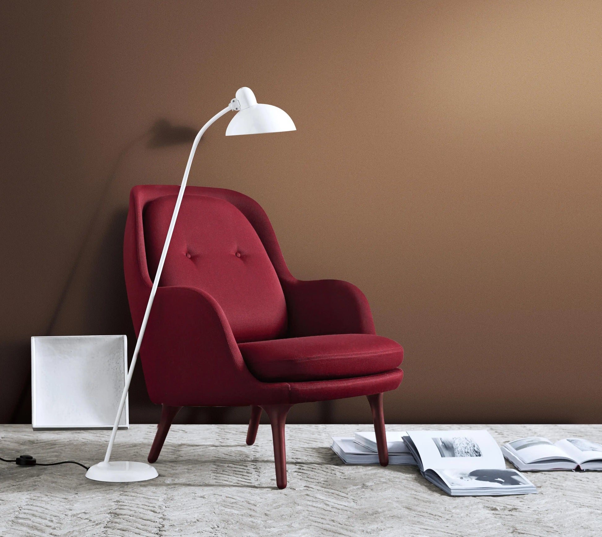 Red armchair with a white floor lamp against a brown wall