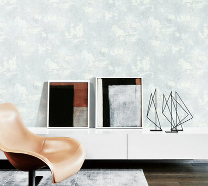 Modern interior with abstract art and a beige chair against a textured wall.