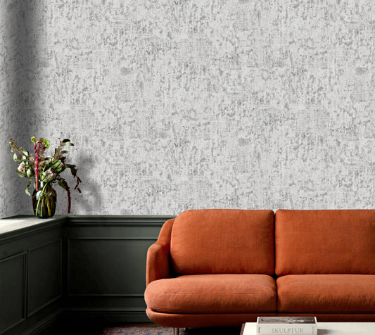 Orange sofa in a room with textured gray wallpaper and a vase of flowers on a shelf.