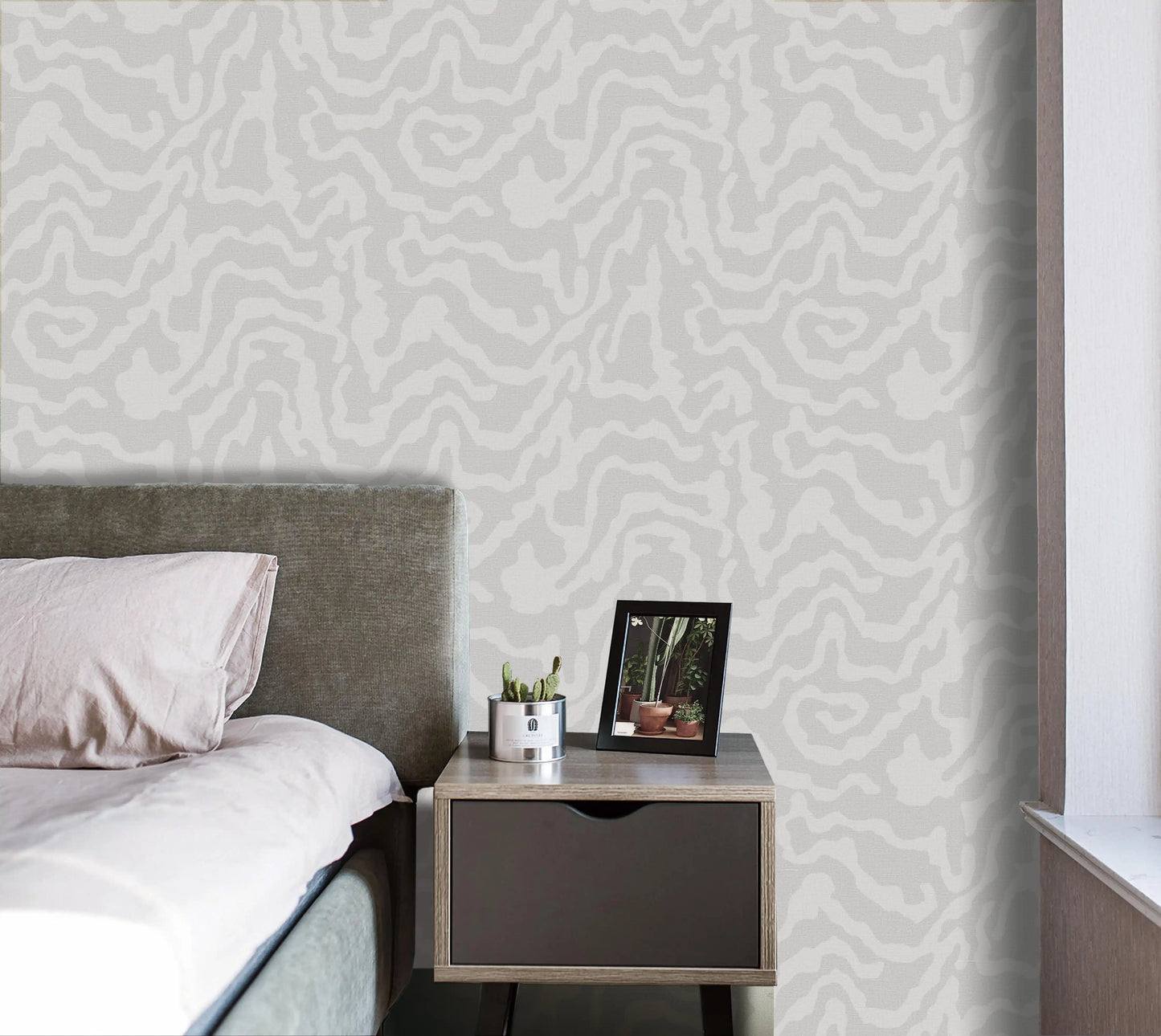 Bedroom with a bed and nightstand against a patterned wall.