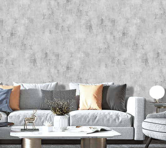 Gray textured wallpaper with a gray sofa and decorative items in a living room setting.