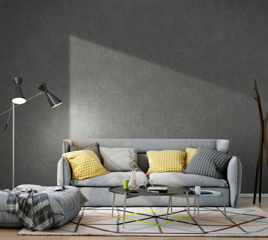 Modern living room with a gray sofa, yellow cushions, and a dark gray wall.