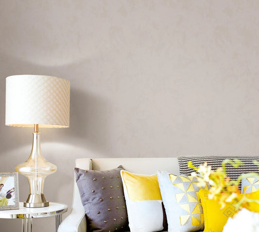 Living room with a lamp, sofa, and decorative pillows on a neutral background