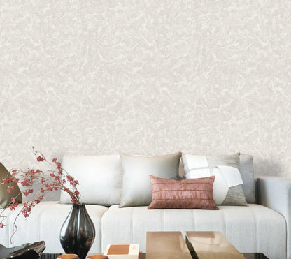 Gray sofa with decorative pillows against a light gray textured wall.